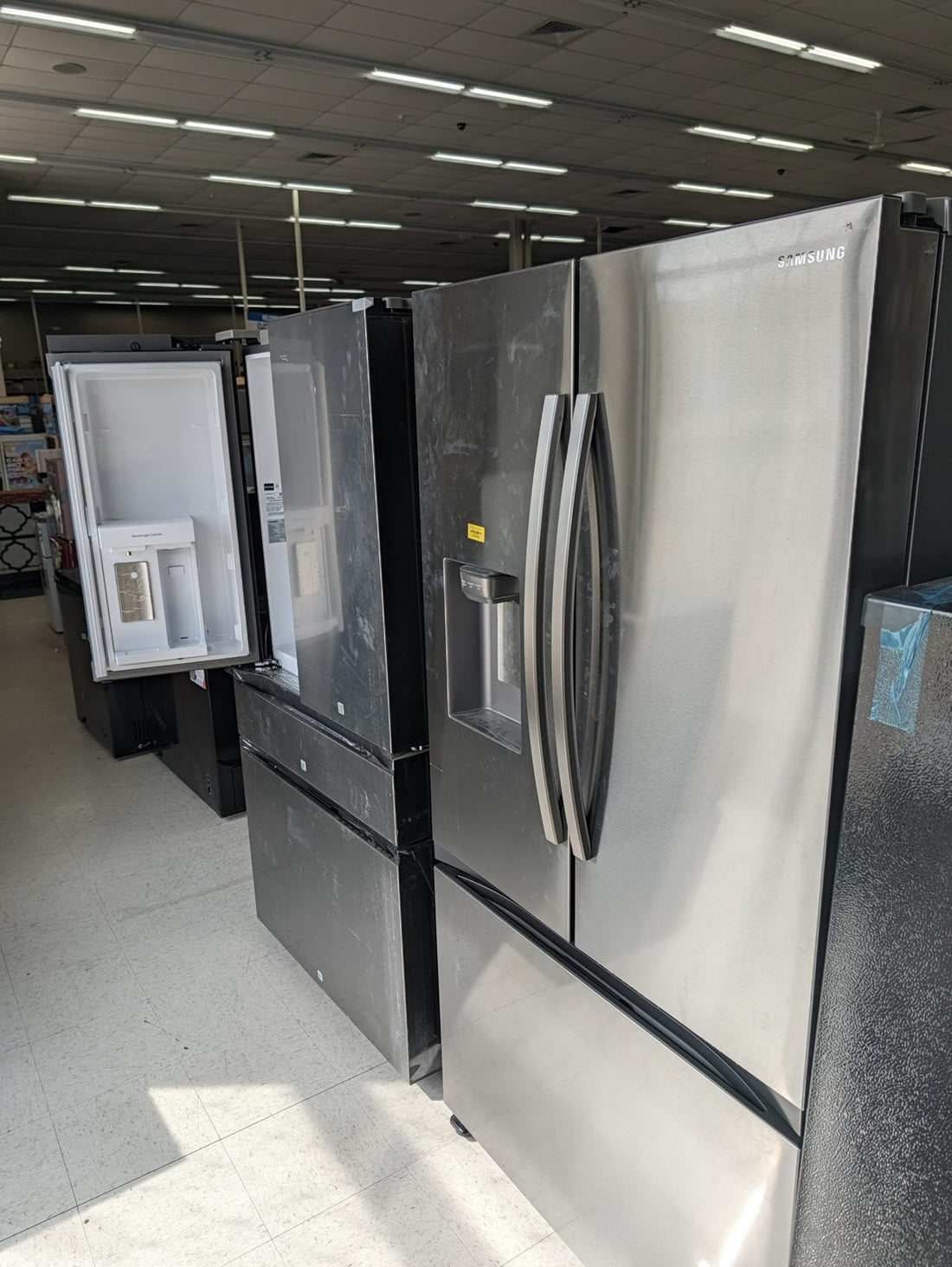 Scratch and dent Samsung french-door refrigerator on the floor at Sheboygan Discount Warehouse