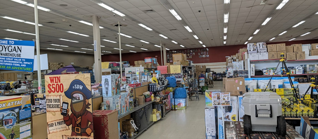 Inside Sheboygan Discount Warehouse: sales floor with the Find Your Treasure sign and pallets of new merchandise